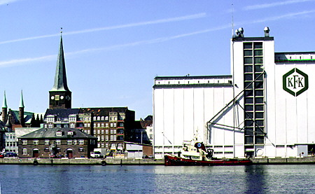 A cathedral contrasts with an industrial building along the Århus harbor. Denmark.
