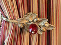 Acorn tie back on curtains made of Bohemian glass at Conde-Charlotte Museum. Mobile, AL.