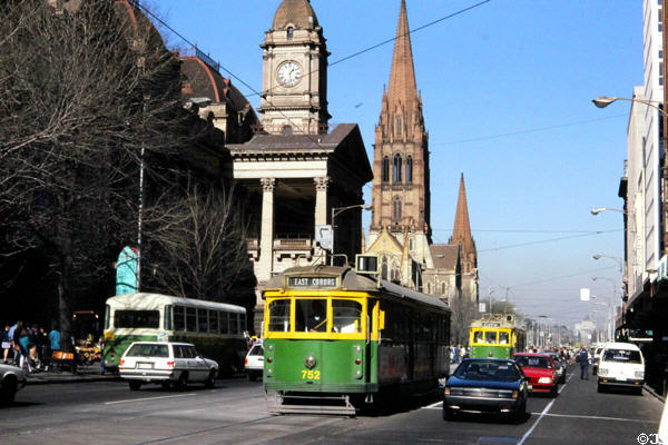 Swanston Street with streetcars in front of Melbourne Town Hall & St Paul's Cathedral. Melbourne, Australia.