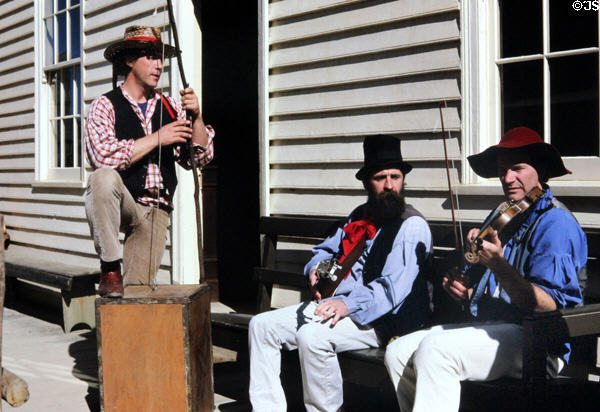 Musicians play on a bench in front of antique building. Ballarat, Australia.