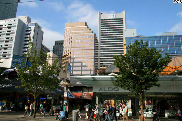 Shops on Robson St. with skyscrapers beyond. Vancouver, BC.