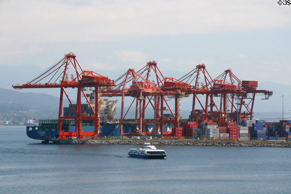Seabus commuter ferry against cranes of Vancouver container port. Vancouver, BC.