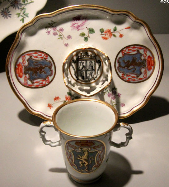 Porcelain chocolate beaker & trembleuse saucer tray painted with arms (c1740) by Du Paquier of Vienna, Austria at Gardiner Museum. Toronto, ON.