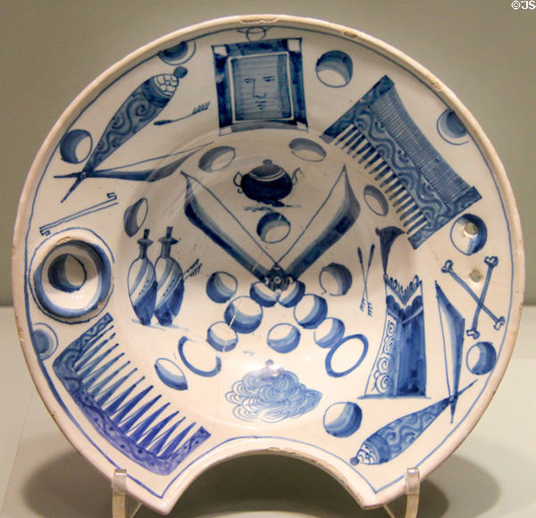 Barber basin decorated with barbering tools including face in small mirror on English delftware (1700-20) from London or Bristol at Gardiner Museum. Toronto, ON.