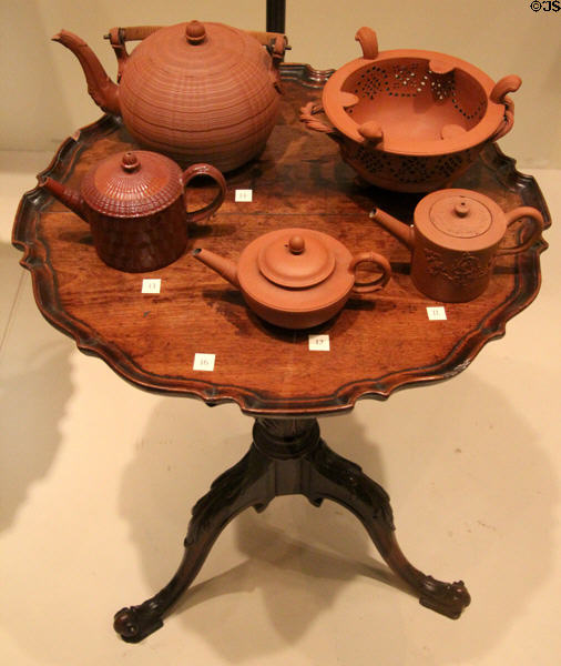 English red stoneware teapots & brazier (late 1770s-1800) atop small round Mahogany English table (c1760) at Royal Ontario Museum. Toronto, ON.