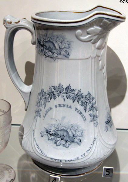 Earthenware pitcher with blue transfer-print of Canadian beaver under slogan "Labor Omnia Vincit" from England at Royal Ontario Museum. Toronto, ON.