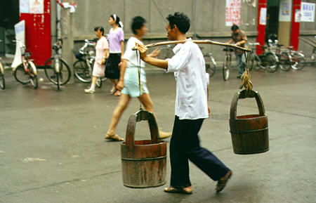 Man carries pails in Yichang. China.