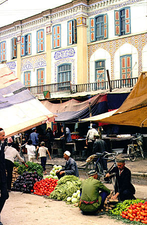 Selling vegetables on the streets of Kashgar during Sunday market. China.