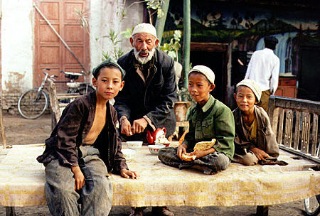 Children sit atop a bed at the Sunday market in Kashgar. China.