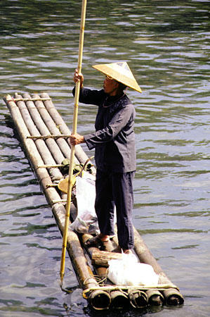 Woman poling a wooden raft along the Li River, Kweilin. China.