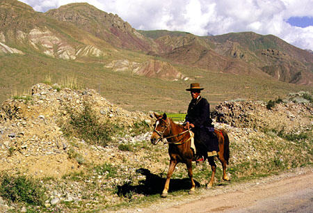 Horseman traveling on a dirt road in Tibet. China.