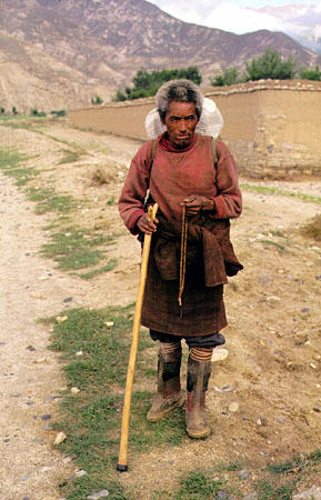 Tibetan man with traditional boots and prayer beads near Lhasa. China.