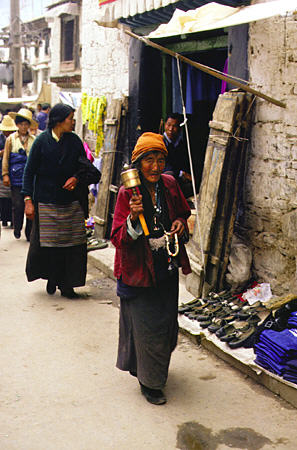 Woman carrying a prayer wheel in Lhasa, Tibet. China.