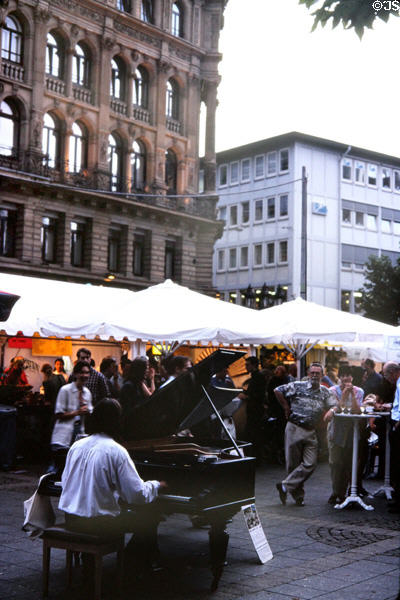 Pianist entertaining diners at outdoor café. Frankfurt am Main, Germany.