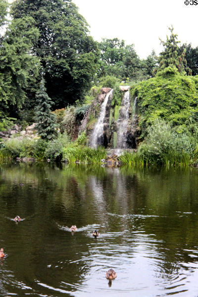 Waterfall flowing into pond in Palm Gardens. Frankfurt am Main, Germany.