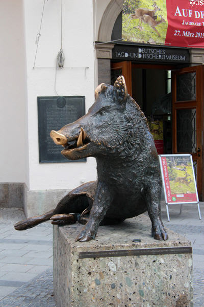 Bronze statue of sitting wild boar based antique style (1960) by Martin Mayer outside German Hunting & Fishing Museum. Munich, Germany.