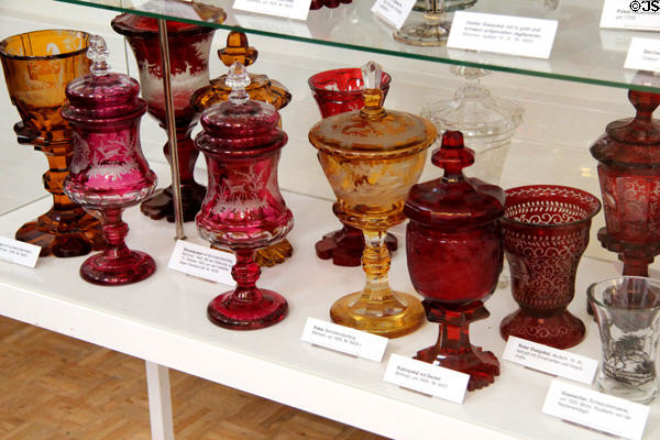 Collection of Bohemian glass vessels (pokals) with hunting images made by cutting away outer layer of colored glass at German Hunting & Fishing Museum. Munich, Germany.