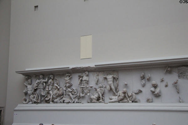 Frieze carving originally around exterior perimeter of Pergamon altar now displayed on interior museum walls in front of the ancient structure (c170 BCE) at Pergamon Museum. Berlin, Germany.