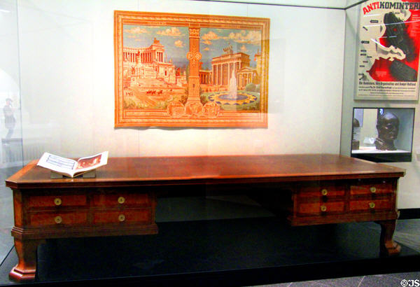 Desk from Hitler's office by Albert Speer under wall hanging featuring Berlin-Rome Axis (c1939) at German Historical Museum. Berlin, Germany.