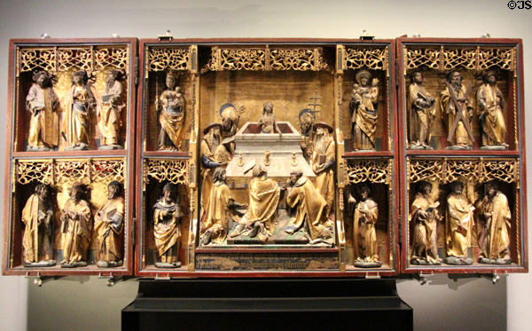 Wooden winged altarpiece centered by Mass of St Gregory flanked by Virgin Mary & Child, Sts Anne & Cosmas & Damian with 12 Apostles in wings (c1525) at Aachen Cathedral Treasury. Aachen, Germany.