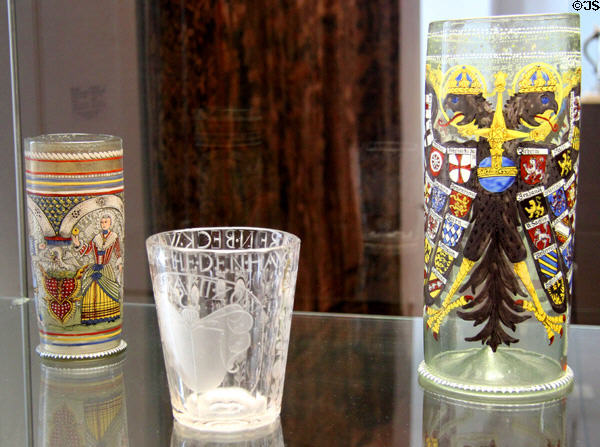 Glass mug with enameled bride & groom (1690), beaker engraved with coat of arms c1680 & imperial eagle humpen (1619) at Schleswig Holstein State Museum. Schleswig, Germany.