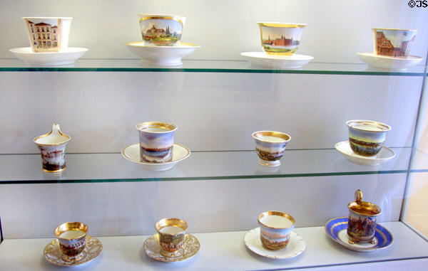 Collection of porcelain coffee cups in Biedermeier style (1840-60) painted with views of Germanic towns & harbors at Schleswig Holstein State Museum. Schleswig, Germany.