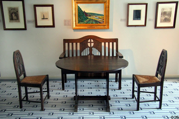Oak & rush weave arm bench & chairs (c1910) around table at Schleswig Holstein State Museum. Schleswig, Germany.