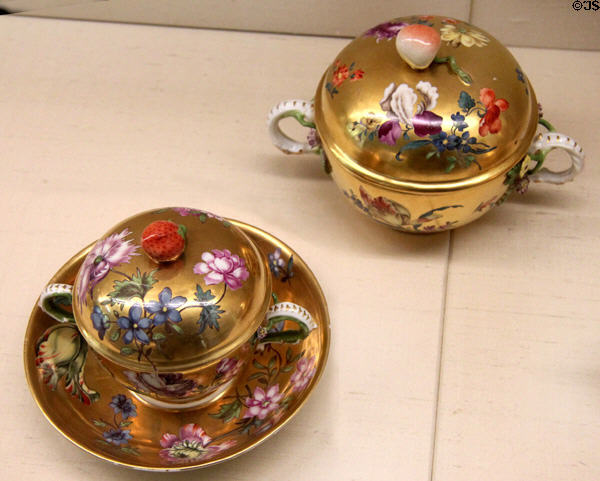 Meissen porcelain gold background covered bouillon cups (c1740) painted with flowers at Meissen porcelain museum at Lustheim Palace. Munich, Germany.