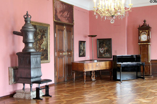 Stove, musical instruments & standing clock in ornate wooden case in Municipal Art Gallery at Schaezler Palace. Augsburg, Germany.