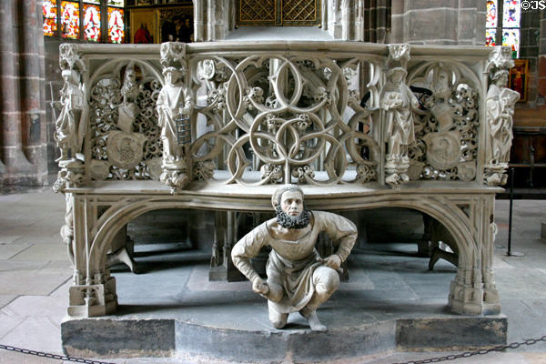 Carved self portrait (1493-6) by Adam Kraft bent & kneeling holding up balcony at St Lawrence Church. Nuremberg, Germany.