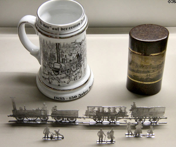 Cast tin model of first German train (1835) pulled by locomotive Adler with mug & box beyond at Nuremberg Transport Museum. Nuremberg, Germany.