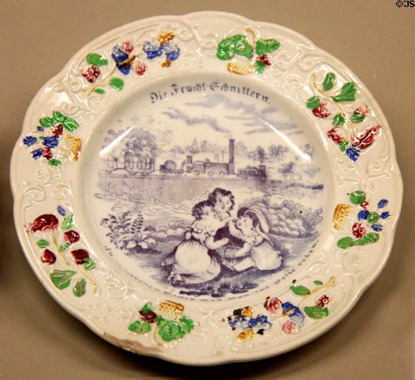 Ceramic promotional plate (c1830) made in England written in German with image of steam train passing three children eating fruit at Nuremberg Transport Museum. Nuremberg, Germany.