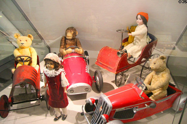Children's pedal cars carrying stuffed animals & dolls at City Toy Museum. Nuremberg, Germany.