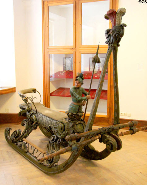 Carved lady's side-saddle horse-drawn racing snow sled with knight on prow at Lindau Municipal Museum. Lindau im Bodensee, Germany.