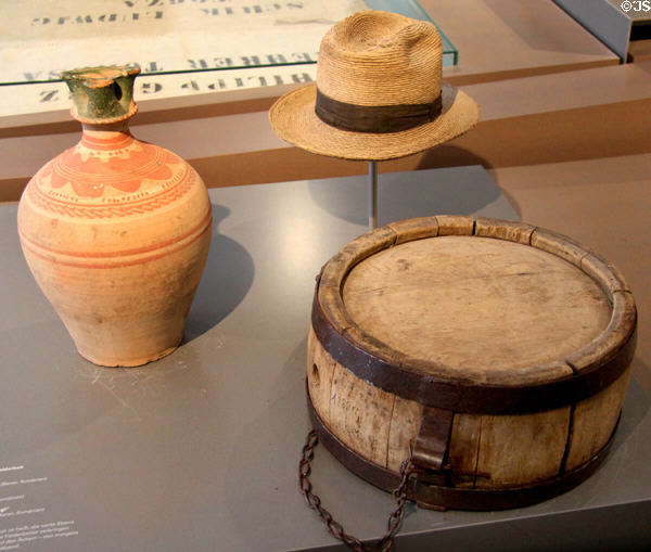 Ceramic water jug, straw hat & wooden water canteen (20thC) from Romania at Danube Schwabian Museum. Ulm, Germany.