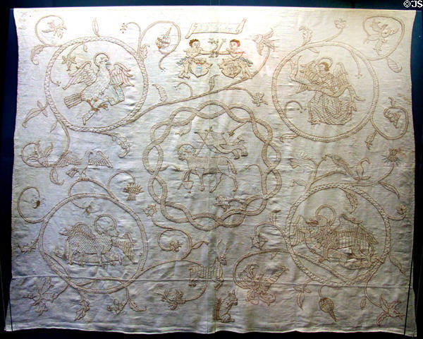 Embroidered cloth (1554) with symbol of St John Baptist surrounded by winged symbols of the Evangelists from Schaffhausen at Ulmer Museum. Ulm, Germany.