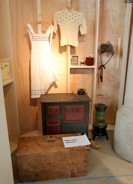 German Post WW II refugee objects like dress made from flour sacks or shoes of straw plus coal & emergency stoves at Schwörhaus museum. Ulm, Germany.