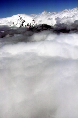 The Andes show through the clouds in flight to Coca from Quito. Ecuador.