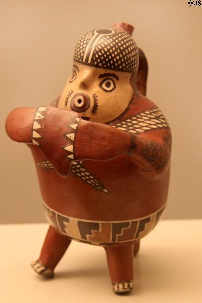 Nazca culture ceramic stirrup-spout bottle of fisherman playing flute, with a net on his back (100-700) from Peru at Museum of America. Madrid, Spain.