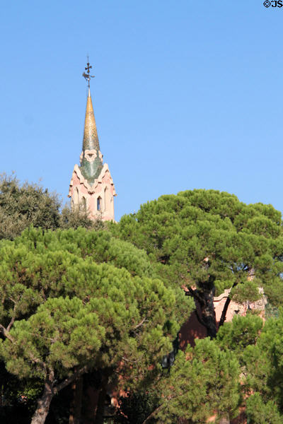 Tower of Gaudi House over trees of Parc Güell. Barcelona, Spain.