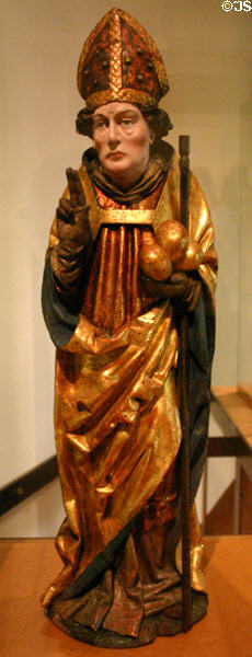 Wooden statue of St Nicholas with three bags of gold (c1500) from upper Rhine in Unterlinden Museum. Colmar, France.