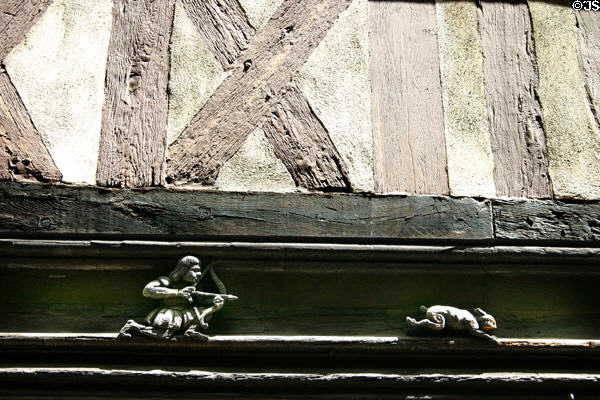 Medieval wood carving of hunter with bow tracking rabbit at 12 rue Verrerie. Dijon, France.
