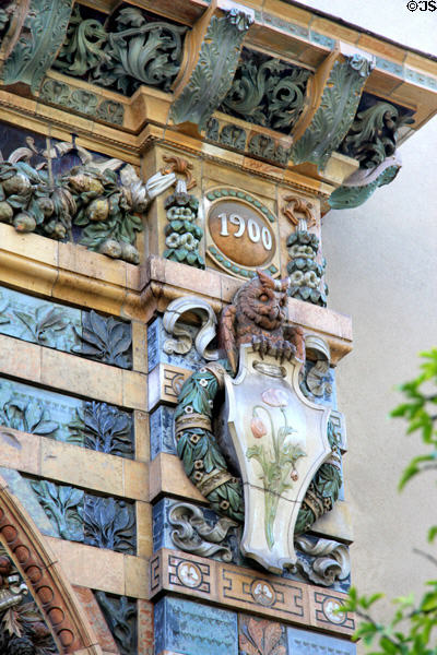 Detail of upper right corner with 1900 date of arch over owl & plaque with poppies on Sevres Arch at St-Germain-des-Prés. Paris, France.
