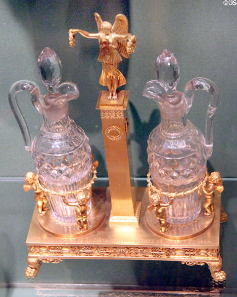 Oil & vinegar cruets on stand with victory column & cupids (1819-23) by Jean-Baptiste-Claude Odiot of Paris at Museum of Decorative Arts. Paris, France.
