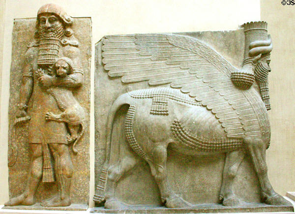 Babylonian full-size relief of hero with lion cub & winged bull with man's head (c710 BC) from citadel of Dur-Sharukkin at the Louvre Museum. Paris, France.