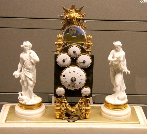 Mantelpiece clock with day & date of month (mid 18thC) by Martinet of London flanked by two statuettes at Arts et Metiers Museum. Paris, France.