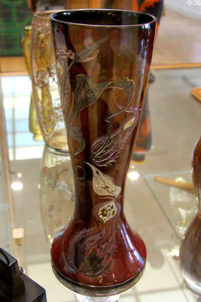 Reddish tall glass vase by Émile Gallé at Arts et Metiers Museum. Paris, France.