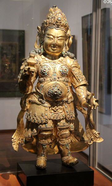 Gilded copper statue with gems of king guardian (15thC) from Tibet at Guimet Museum. Paris, France.