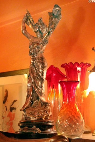 Art Nouveau metal statuette plus colored glass vases at Maxim's Art Nouveau Collection 1900. Paris, France.