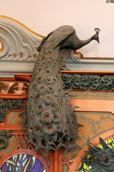 Elaborate ironwork peacock (1901) in Art Nouveau style perching on molding between wall & ceiling inside Boutique Fouquet at Carnavalet Museum. Paris, France.